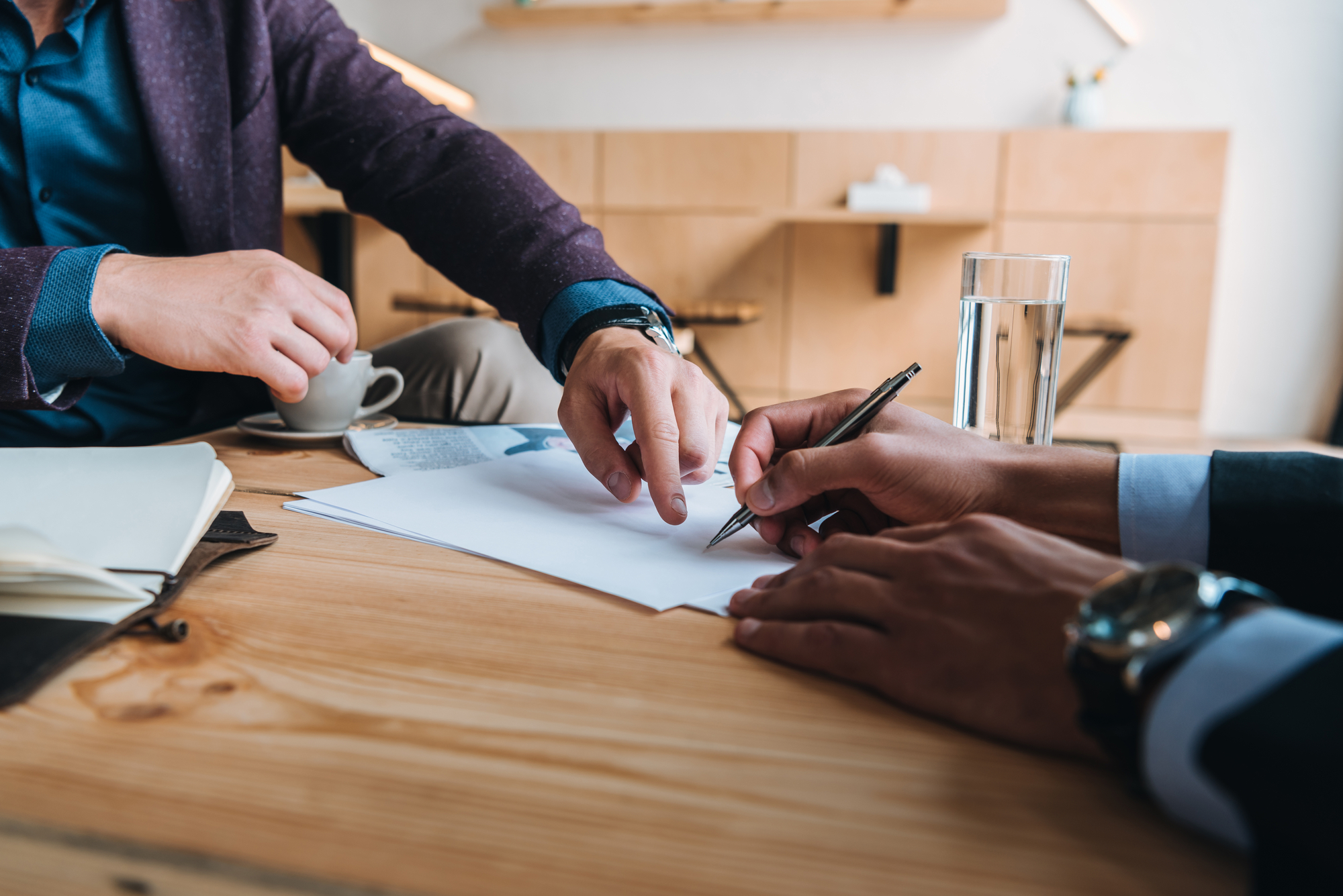 Businessmen signing contract at meeting