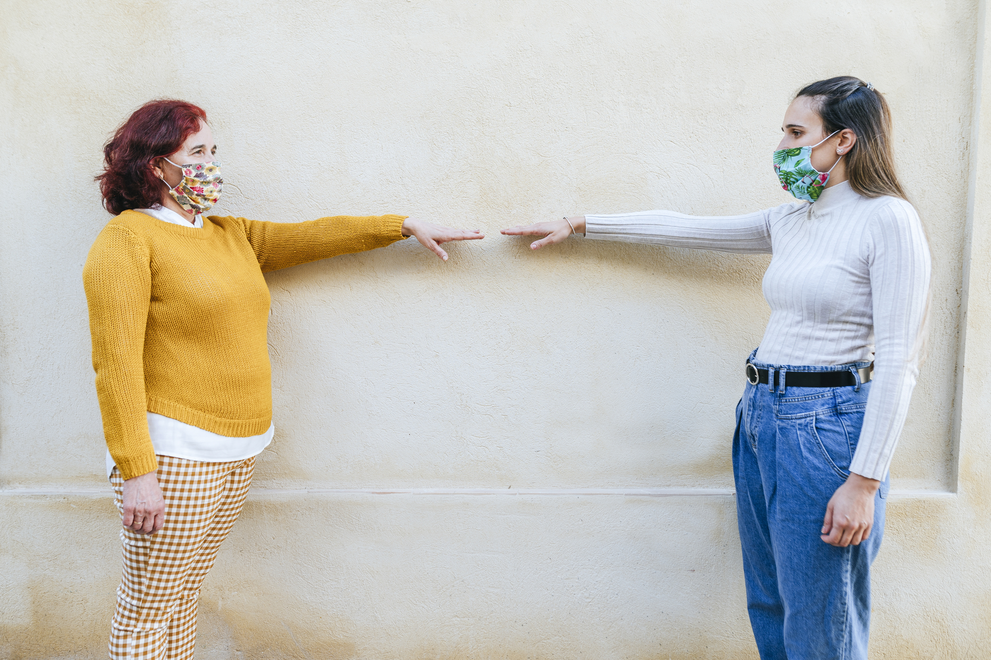 Two women with face masks representing social distancing